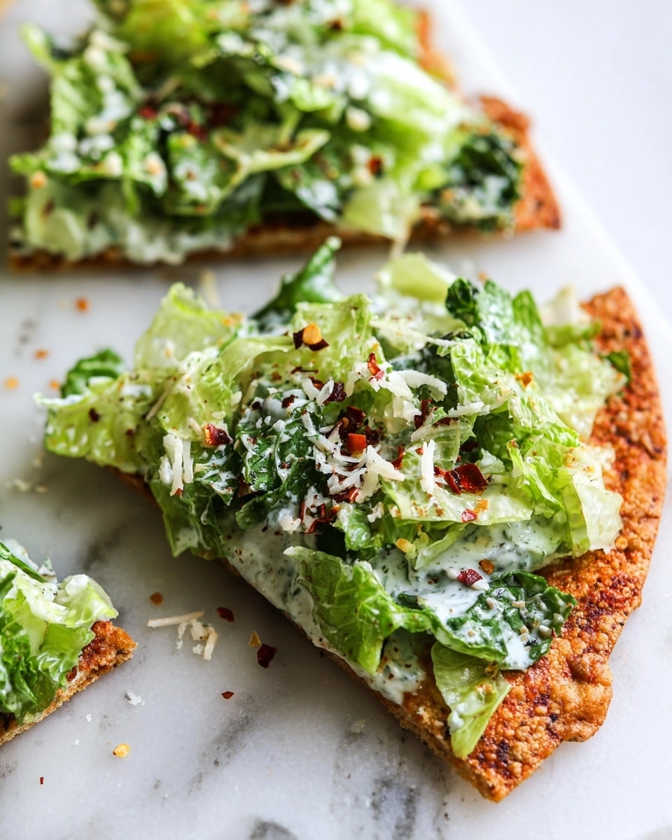 The image shows a close-up of a slice of crispy thin flatbread topped with a creamy green salad, placed on a white marbled surface. The flatbread layer is golden-brown with a rough, crunchy texture and some small dark spots. On top, there is a thick layer of fresh chopped lettuce with a creamy white dressing mixed in. The salad includes dark and light green leaves, sprinkled with small red chili flakes and white cheese shavings. Another slice of the flatbread with the same topping is visible slightly out of focus in the background. Photo taken with an iphone --ar 4:5 --v 7