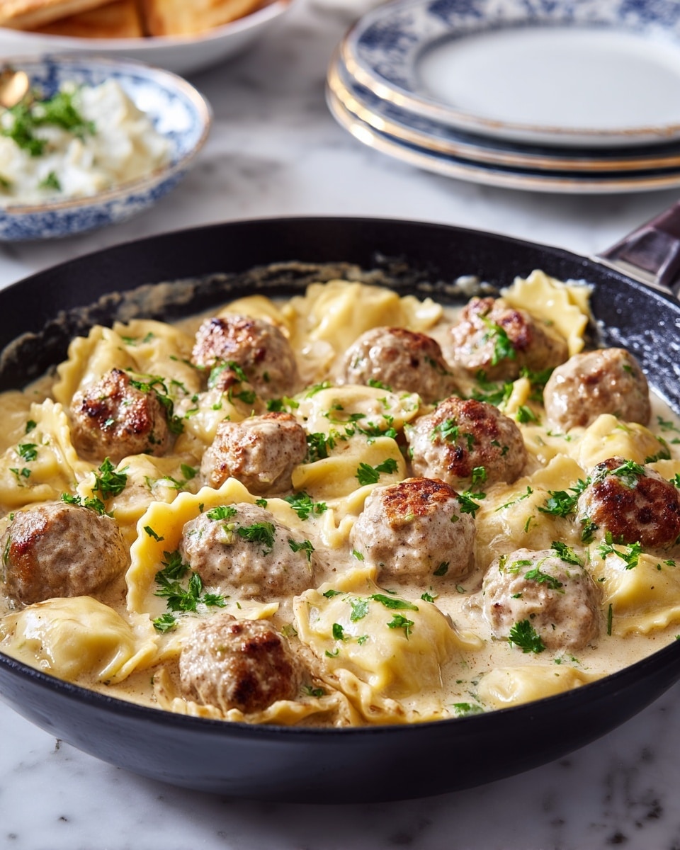 A black skillet holds a cooked dish made of golden-brown meatballs and large, soft ravioli pasta in a thick creamy sauce. The meatballs are small, round, and have a crispy browned outside, scattered evenly among the ravioli, which are plump and have slightly crinkled edges. Fresh green parsley leaves are sprinkled lightly on top, adding a pop of color against the warm brown and beige hues of the sauce and pasta. The skillet is placed on a white marbled surface with blurred plates and bowls in the background. photo taken with an iphone --ar 4:5 --v 7